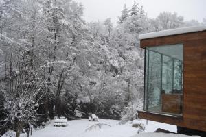 San SalvadorAlesga Hotel Rural - Valles del Oso -Asturias的雪中小屋,有树在后面