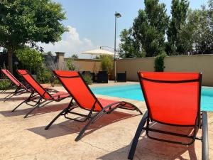 艾居厄河畔卡马勒La Maison de Caillette的游泳池旁的一排椅子