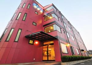 大村市Omura - Hotel / Vacation STAY 46227的一座高大的红色建筑,设有窗户