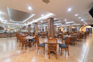 瓜达拉哈拉马里布酒店的一间带木桌椅的餐厅和一间酒吧