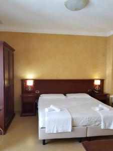 卡斯特布奥诺天堂德勒玛多尼酒店的一间卧室设有两张床和两个床头柜