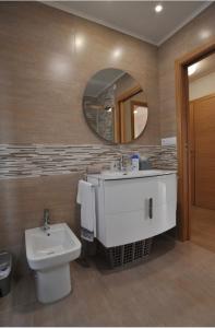 维拉加尔西亚·德·阿劳萨Apartamentos Playa Compostela的一间带水槽、卫生间和镜子的浴室