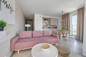格但斯克Wave Apartments - Olivia Park的客厅配有粉红色的沙发和桌子