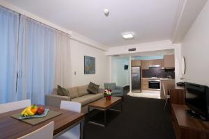 悉尼APX世界广场公寓式酒店的客厅配有沙发和桌子