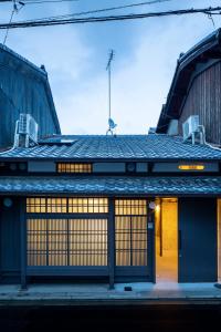 京都KOU Nishijin的一座带两扇门和两把椅子的建筑