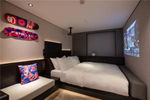 广州锋·态度酒店（广州火车站店）的一间小卧室,配有床和屏幕