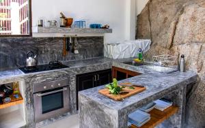 涛岛Joy's homestay的厨房配有大理石台面和炉灶。