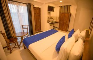 科伦坡Opulence Colombo的一间卧室配有一张床、一张桌子和一个窗户。