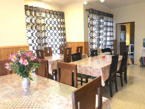 努沃勒埃利耶山镇小屋住宿加早餐旅馆的一间带桌椅和花瓶的餐厅
