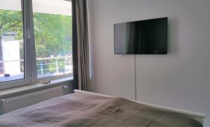 柏林HOLI DAY SPA Appartement 1的卧室配有壁挂式平面电视。