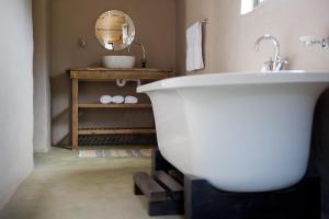 蒙塔古非洲格姆旅舍的浴室配有白色浴缸和水槽