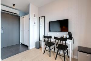 索波特Apartamenty Bema4 Sopot的一间设有两把椅子和一张桌子及电视的房间
