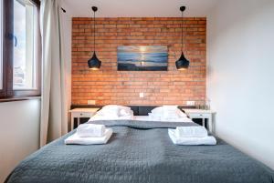 索波特Apartamenty Bema4 Sopot的一间卧室设有两张床和砖墙