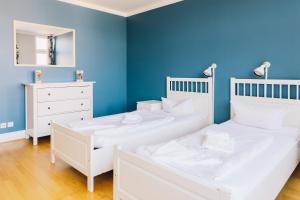 柏林圣克里斯托弗公寓酒店的蓝色墙壁客房的两张床