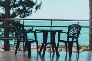 科布列季Hotel Solidarity的阳台配有一张桌子和两把椅子,享有海景