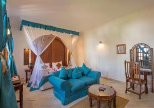 桑给巴尔赛伊达温泉酒店 的客厅配有蓝色的沙发和床。