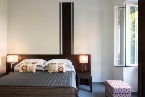 罗马特米尼公寓酒店的一间卧室配有一张大床,上面有两盏灯