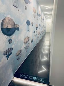 玛格丽塔萨沃亚MARGHERITA BOUTIQUE ROOMS的一座建筑里装有热气球壁画的自动扶梯