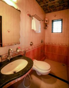 孟买班德拉幸运酒店的一间带水槽和卫生间的浴室