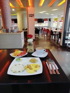 皮塔利托Hotel Grand Premium Plaza的餐桌,带两盘食物和一杯咖啡的桌子
