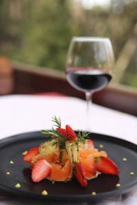 地拉那德雷瑞餐厅酒店的黑盘,上面有草莓和一杯葡萄酒
