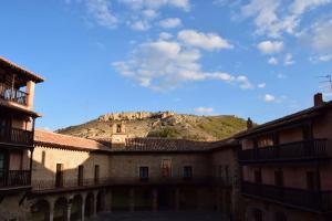 阿尔巴拉辛Casa Balcón de Albarracín的一座以山为背景的古老建筑