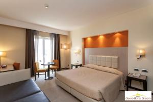 阿尔贝罗贝洛奥林波格兰德酒店的酒店客房配有一张床铺和一张桌子。