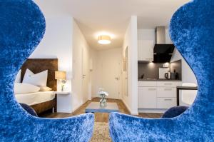 瓦尔内明德Appartements an der Golfanlage的一间卧室配有一张床和两张蓝色椅子