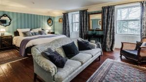 罗斯伯里The Orchard House的一间大卧室,配有一张床和一张沙发