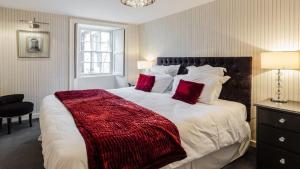 罗斯伯里The Orchard House的一间卧室配有一张带红色枕头的大床