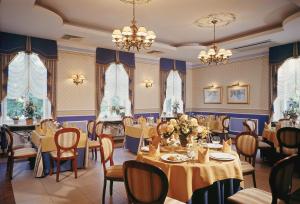 弗沃茨瓦韦克亚历山大酒店的用餐室配有桌椅和吊灯。