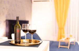 萨格勒布Jacuzzi studio apartman Mare's的桌子上放有一瓶葡萄酒和两杯酒