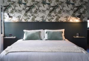朴茨茅斯THE INN DOWNTOWN - Portsmouth, NH的一间卧室配有一张带花卉壁纸的大床