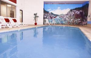 LibbyVenture Inn的一个带椅子和壁画的大型游泳池