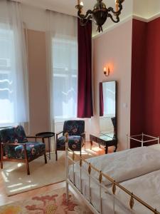 布达佩斯Madana apartman的一间卧室配有一张床、两把椅子和镜子
