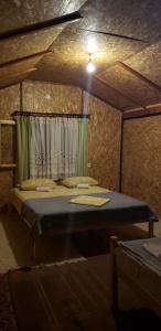 AndrijevicaEthno Village Koljeno Camp & Bungalows的卧室,卧室配有床,卧室配有窗帘