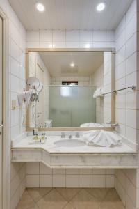 瓜拉普阿瓦Kuster Hotel的一间带大水槽和镜子的浴室
