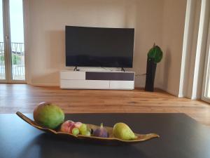 SubingenWohnstation的客厅里的桌子上放一碗水果