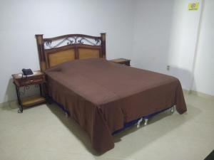 亚松森Hotel Boggiani的一张带棕色床罩和2晚床架的床