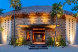 图卢姆Hotel Ma'xanab Tulum的拥有茅草屋顶和棕榈树的度假酒店