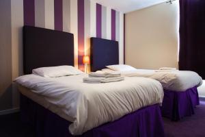 朴次茅斯白金汉公爵酒店的两张位于酒店客房的床,配有毛巾