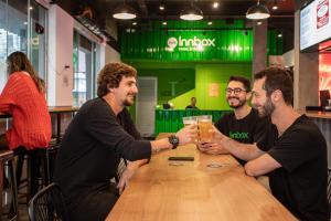 弗洛里亚诺波利斯Innbox - Centro的一群坐在桌边喝啤酒的人
