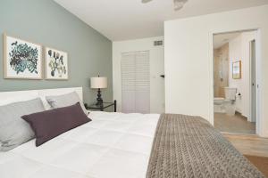 劳德代尔堡3 bedrooms apartment step from the beach的白色的卧室设有一张大床和一间浴室。