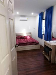 莱卡邦Happy Home Hostel的一间卧室配有一张带红色床单和蓝色窗帘的床