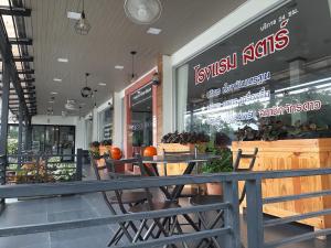 坤西育府สตาร์ รีสอร์ท (สี่แยก จปร)的商店前带桌椅的餐厅