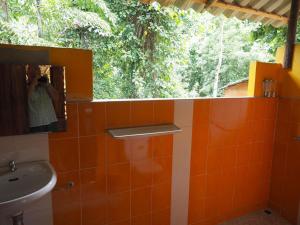 象岛利特一登小屋的浴室配有水槽、镜子和树木