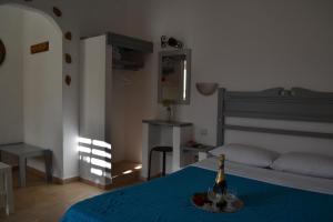斯基罗斯岛Skyros Koxilas Studios的一间卧室配有一张床和一瓶香槟