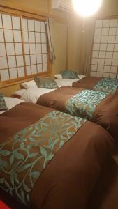 富士吉田市Tsukitei1的一间房间里三张床的组合