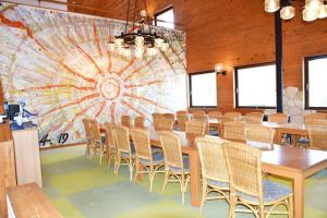 土庄町Taiyou no Ouchi的大房间设有一张长桌子和椅子