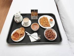 乌代浦Hotel Delight的盘子里装有早餐食品的食品